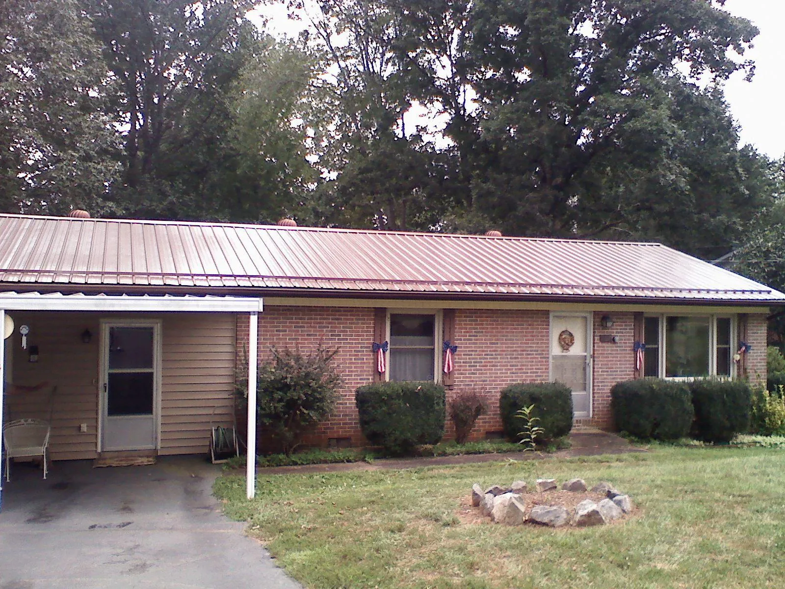 Bronze metal roof and carport on a brick ranch home — Roof Repair work by our crew in Ivor
